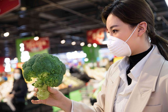 戴口罩的青年女人在超市挑选青菜货架清晰拍摄