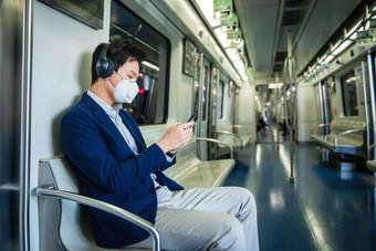 青年男子戴口罩乘坐地铁耳机清晰照片