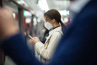 戴口罩的年轻女人站在<strong>地铁</strong>站台上