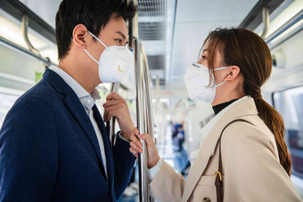 戴口罩的青年情侣乘坐地铁防病毒口罩清晰图片