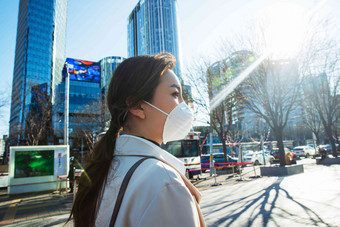 青年女人戴口罩在户外行走预防病毒相片