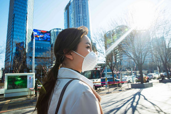 青年女人戴口罩在户外行走