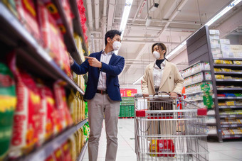 戴口罩的青年夫妇在超市购物食品高质量镜头