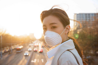 青年女人戴口罩在户外行走预防高清图片