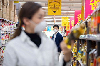 青年夫妇戴口罩在超市购物防病毒口罩图片