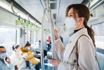 戴口罩的年轻女人乘坐地铁公共交通拍摄