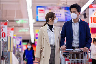 戴口罩的青年夫妇在超市购物商品摄影图