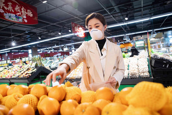 戴口罩的青年女人在超市购买水果防疫清晰场景