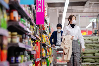 青年夫妇戴口罩在超市购物户内高清场景