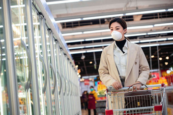 戴口罩的青年女人在<strong>超市</strong>购物