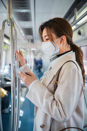 青年女人在地铁上看手机