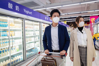 戴口罩的青年夫妇在超市购物