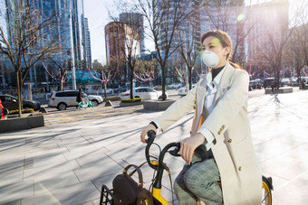 戴口罩的年轻女人骑共享单车一个人氛围照片
