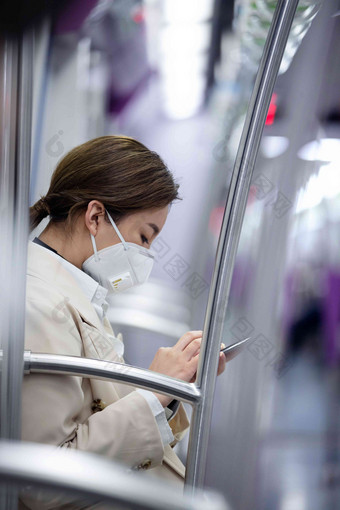 青年女人在地铁上看手机病毒氛围相片