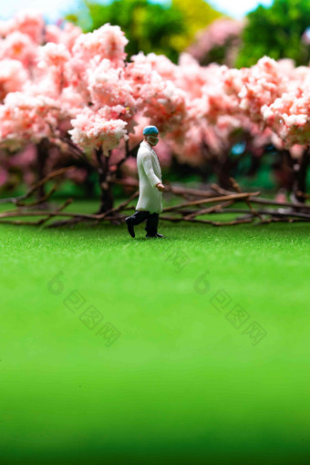 樱花树下草地上医生行走的身影服务高清图片