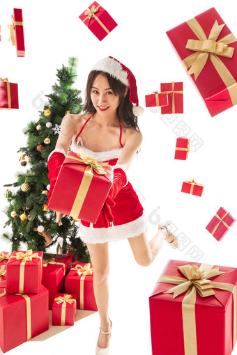 穿着圣诞服的年轻女人拿着圣诞礼物圣诞树写实场景