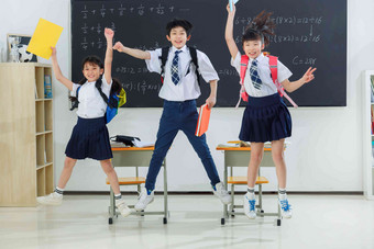 快乐的小学生在教室里欢呼跳跃教科书高清素材