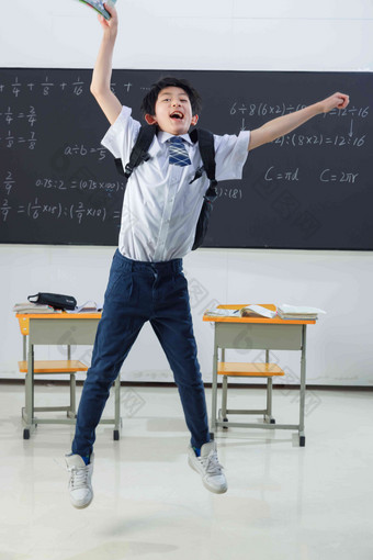 快乐的小学男生在教室里欢呼跳跃