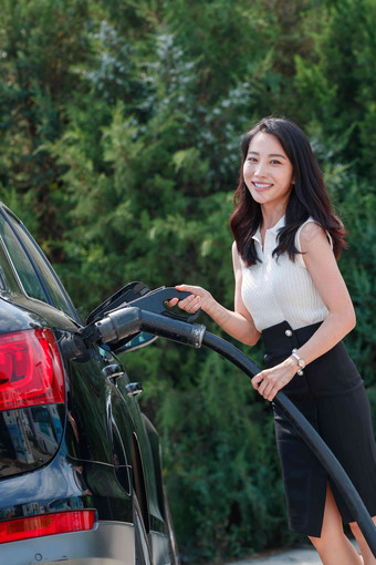 漂亮的青年女人给<strong>汽车</strong>充电