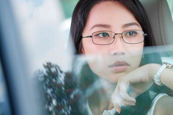 青年女人坐在汽车里向外看