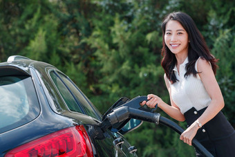 漂亮的青年女人给汽车<strong>充电</strong>