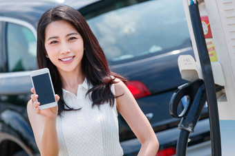 青年女人使用手机自助充电汽车青年女人高质量拍摄