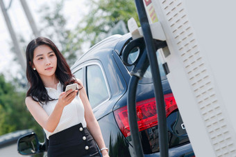 青年女人使用手机自助充电汽车美女高质量图片
