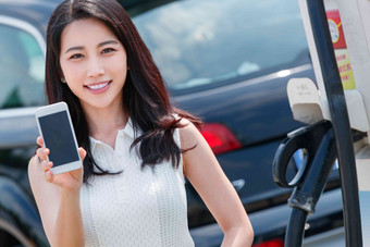 青年女人使用手机自助充电汽车时尚写实摄影图