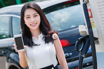 青年女人使用手机自助充电汽车女人写实照片