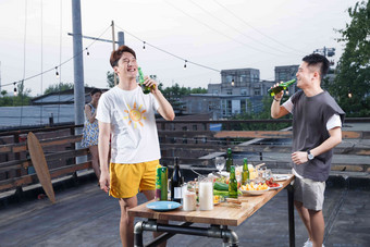 两个青年人喝啤酒休闲活动高清照片