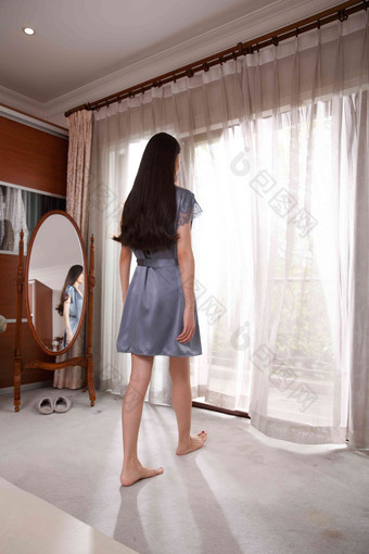 青年女人拉开窗帘往外看住房高质量照片