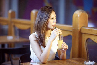 青年女人在喝果汁水平构图照片