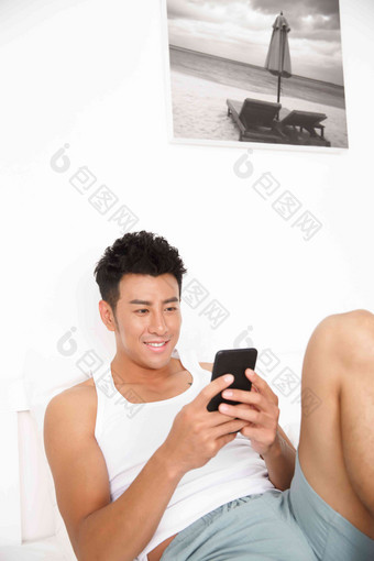 青年男人在卧室玩手机互联网高端素材