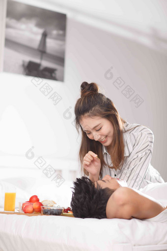 青年情侣在床上吃早餐