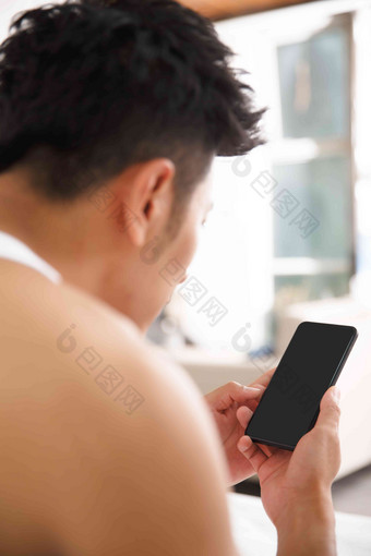 青年男人在卧室玩手机亚洲摄影图