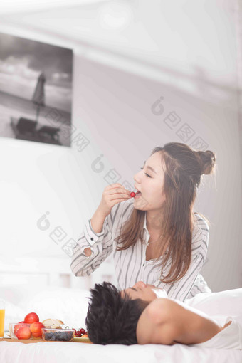 青年情侣在床上吃早餐