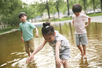 快乐儿童在户外蹚水玩相伴氛围摄影图