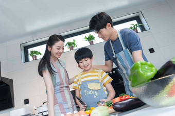 年轻父母教儿子学做饭厨具清晰摄影图