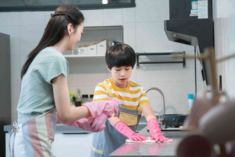 年轻妈妈指导儿子在厨房打扫卫生亚洲人摄影图