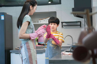年轻妈妈指导儿子在厨房打扫卫生青年人高端影相