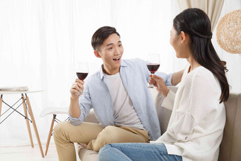 青年情侣喝红酒微笑摄影图