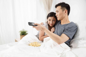 青年情侣坐着床上看电视床高质量拍摄