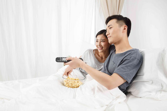 青年情侣坐着床上看电视刺激高质量镜头