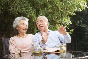 休闲的老年夫妇坐在院子里