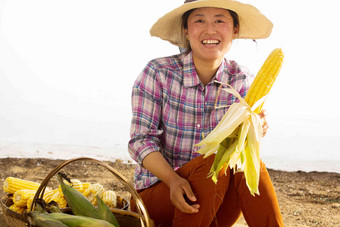 中年女人拿着玉米