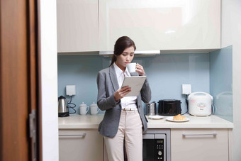 青年女人在厨房使用平板电脑人高端拍摄