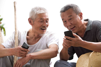两位老农民在聊天微笑的写实照片