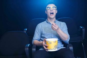 一个青年男人在电影院看电影