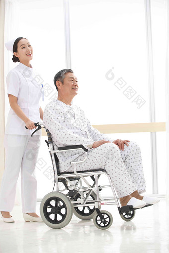 女护士推着坐在轮椅上的<strong>老人</strong>
