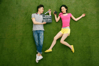 青年情侣躺在草地上玩耍水平构图高端素材